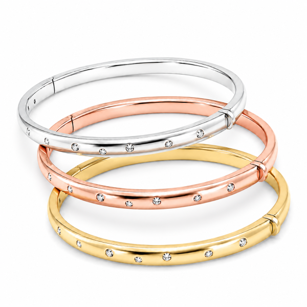 Three silver bangle bracelets in silver, 14k yellow gold plating, and 14k rose gold plating, each with embedded diamond simulants on a white background.